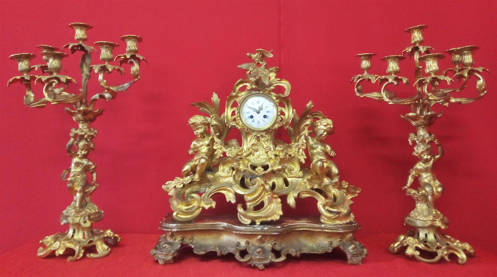 Orologio e Coppia di candelabri in bronzo dorato