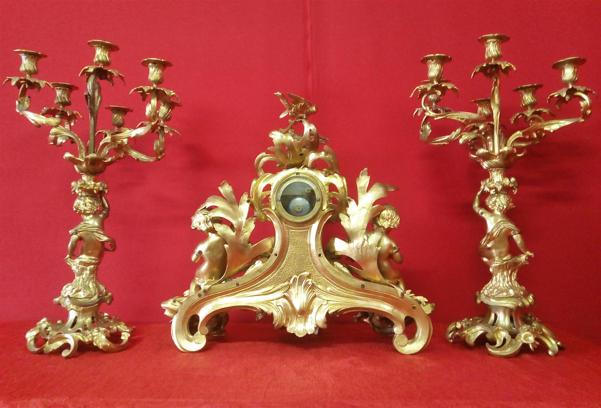 Orologio e Coppia di candelabri in bronzo dorato